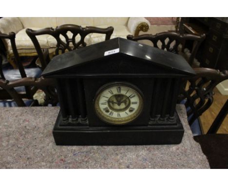 A BLACK SLATE MANTLE CLOCK of architectural form the dial with Roman numerals between reeded columns on platform base 33cm (h