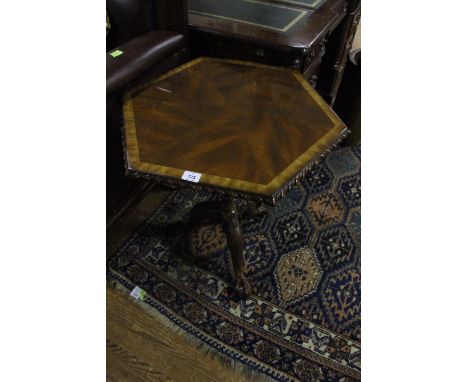 A WALNUT CROSS BANDED OCCASIONAL TABLE of octagonal outline the shaped moulded top with gadrooned rim on tripod support with 