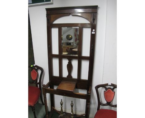 A MAHOGANY HAT, COAT AND STICK STAND with rectangular bevelled glass mirror above a hinged compartment raised on turned suppo