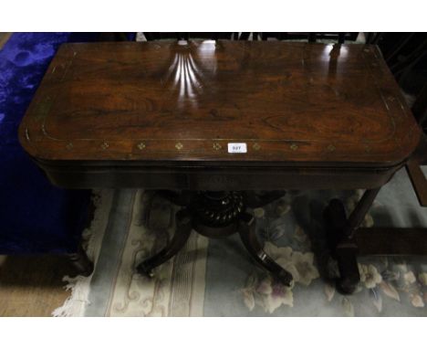 A REGENCY ROSEWOOD AND BRASS INLAID FOLD OVER CARD TABLE the rectangular hinged top containing a baize lined interior above a