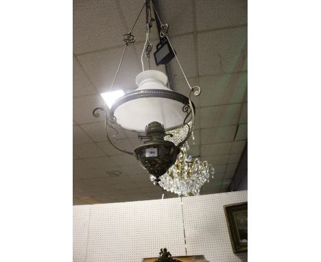 A VICTORIAN BRASS HANGING OIL LAMP with opaline glass shade with scroll arms