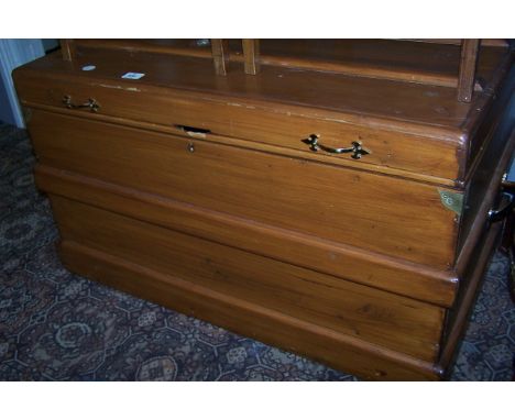 A PINE TRUNK with hinged lid and brass handles