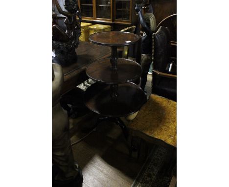 A GEORGIAN MAHOGANY THREE TIER DUMB WAITER each circular dish raised on a spiral twist column and tripod support with pad fee