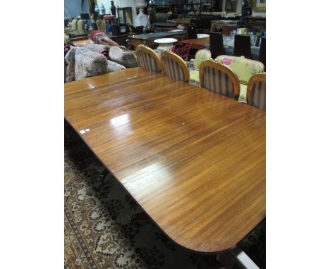 A REGENCY STYLE MAHOGANY DINING TABLE the rectangular moulded top with rounded corners raised on twin tripod supports