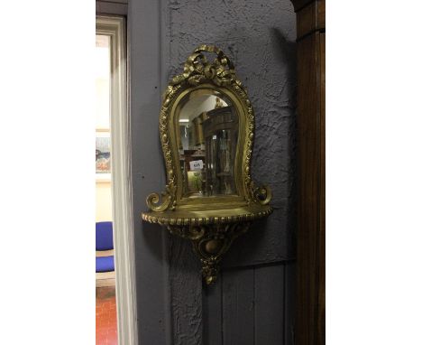 A CONTINENTAL GILT FRAME MIRROR the shaped bevelled glass plate within an egg and dart moulded frame with ribbon tied crestin