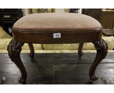 A CHIPPENDALE STYLE MAHOGANY STOOL the oval upholstered seat above a plain apron on cabriole legs with scroll toes and carved