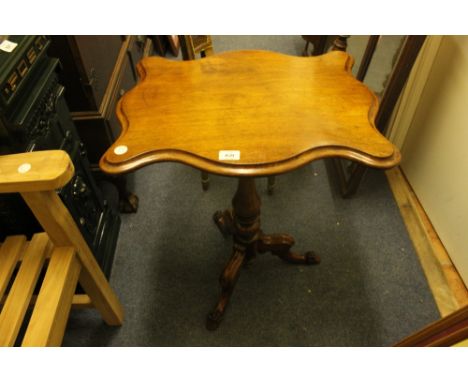 A VICTORIAN MAHOGANY WINE TABLE the serpentine moulded top above a baluster column on tripod support