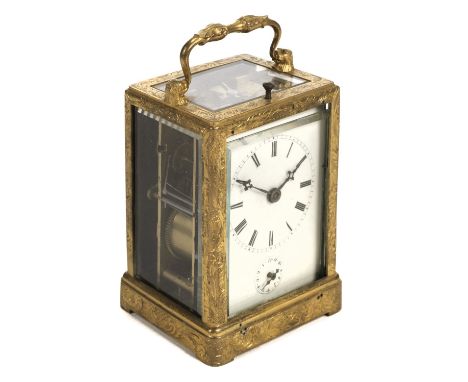 * Clock. An Edwardian carriage timepiece, the lacquered brass case finely engraved with foliate scrolls, the swing handle wit