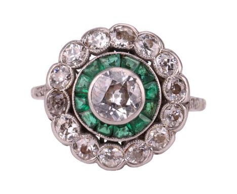 An Art Deco diamond and emerald target ring, the round cluster comprised of a central old-cut diamond of estimated 0.50ct, en