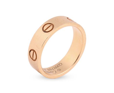 Cartier - a ‘Love’ ring in 18ct yellow gold, the flat polished band decorated with screw-head motifs, signed and numbered, st