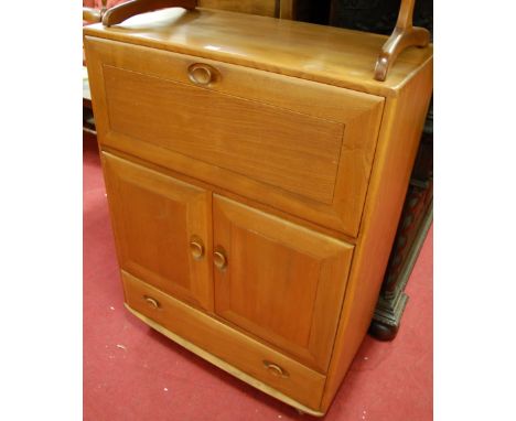 An Ercol light elm Windsor 469 drinks cabinet having hinged fall front, twin cupboard doors and single long lower drawer, wid