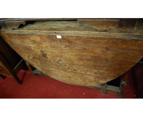An 18th century oak drop leaf dining table, having a gate leg action