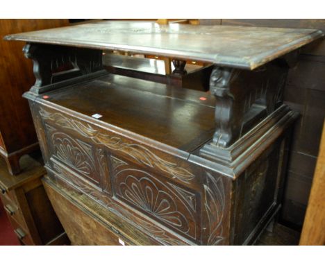 An early 20th century line carved oak twin panelled fold-over monks bench, having a hinged box seat base, width 106.5cm