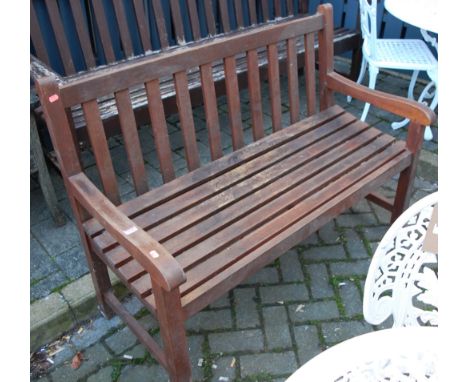 A contemporary stained and slatted teak two-seater garden bench, w.122cm