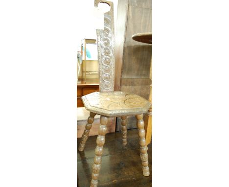 A relief carved oak spinning seat raised on bobbin turned supports