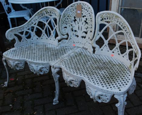 A Victorian style white painted and pierced metal three-seater garden bench, having a shaped back, w.138cm