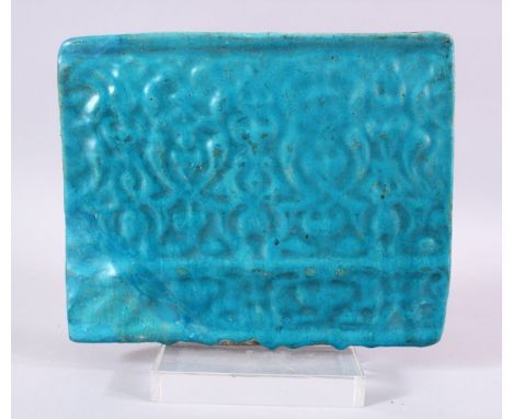 AN ISLAMIC TURQUOISE TILE SECTION, with moulded motif design, 20cm x 24cm.