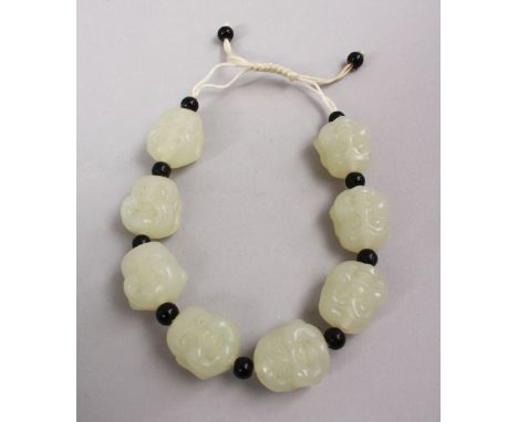 A SET OF CHINESE CARVED CELADON JADE BEAD BRACELETS, the beads carved in the form of buddhas faces with spacers, 20cm open ap