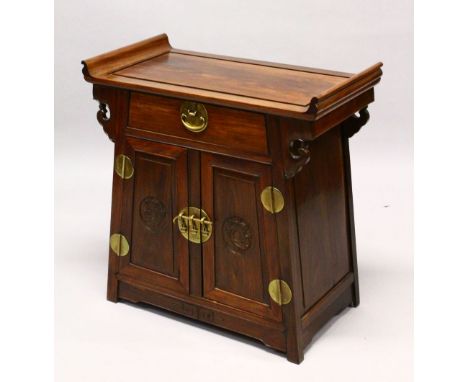 AN EARLY 20TH CENTURY CHINESE ALTER STYLE CABINET with scroll ends, a single small drawer over a pair of carved panelled cupb