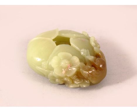 A SMALL CELADON JADE BUD FORM BRUSHWASHER, the side decorated in high relief with a tengu and blossoms, the stone with russet