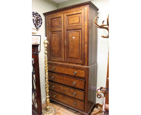 Georgian oak and mahogany linen press having two inlaid panelled doors above a base of four long drawers on shaped bracket fe