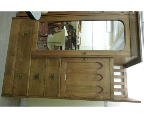 A late 19th/early 20thC Liberty & Co ash wardrobe with Art Nouveau inspired brass fittings, having a platform top, over a thr