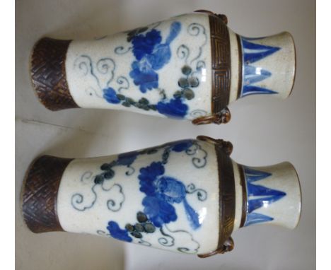 A pair of early 20thC Chinese Export porcelain vases of baluster form, having wide necks and moulded ring mask handles, decor