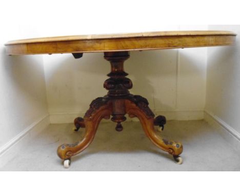 A mid Victorian walnut breakfast table, the figured and quarter veneered oval tip-top having a moulded edge, over a profusely