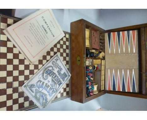 An early 20thC mahogany games compendium, having straight sides and a hinged lid, the interior fitted with backgammon, chess,