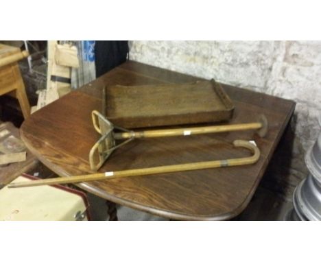 A walking stick with a silver band, a wooden bed/ lap tray and a shooting stick with bergere seat.