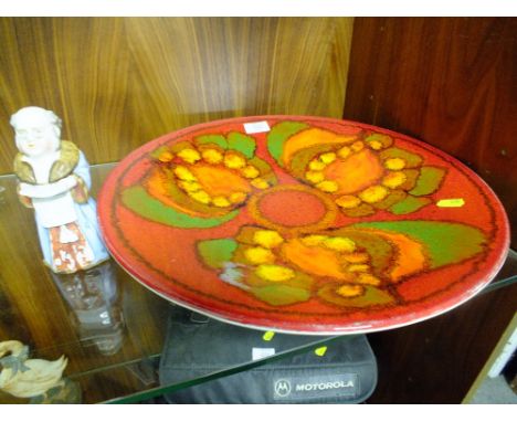 A LARGE POOLE POTTERY CHARGER AND A CERAMIC FIGURE