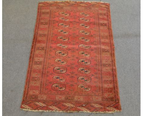Persian rug, red field with Tekke gulls, two rows of eleven guls, enclosed by borders, 174 x 104cm.