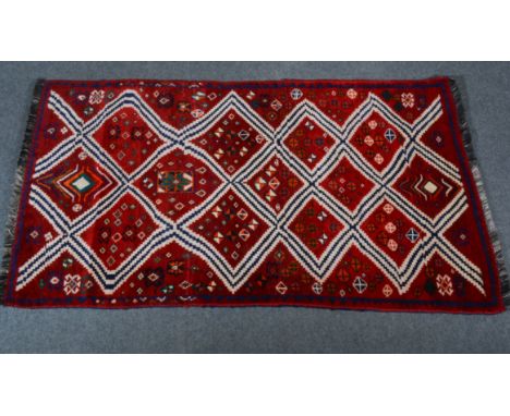 Gabbeh wool rug; with diamond shaped panels on a maroon ground,geometric border, 170 x 105cm.