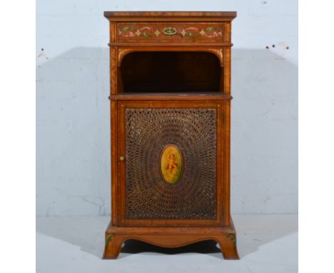 Edwardian satinwood and painted pedestal cupboard, rectangular top, frieze drawer above an arch, cane panelled doors, splayed