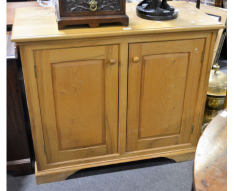 A modern pine side cupboard, moulded rectangular top, pair of cupboard doors, bracket feeet, W102cm x D50cm x H85cm.
