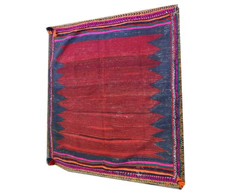 A Kilim style rug, maroon field against a navy ground, enclosed by vibrant borders, 120 x 115cm.