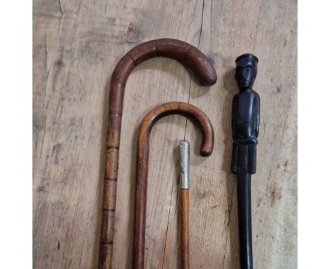 A group of 4 sticks to include an African carved ebony stick, a swagger stick marked EGYPT 44 &amp; 2&nbsp; walking sticks.