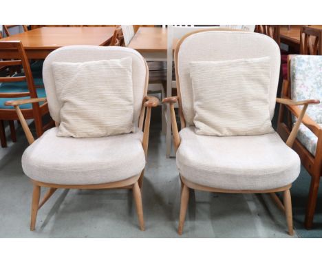 A lot comprising two assorted Ercol elm and beech framed open armchairs with cream upholstered cushions (2) Condition Report: