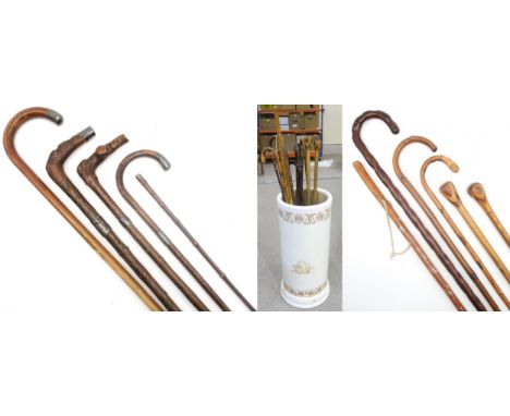 A collection of walking sticks, to include silver-mounted and geometrically inlaid examples, an eastern bamboo cane carved wi