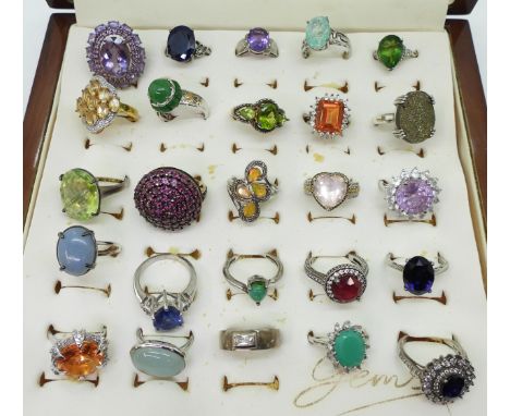 Twenty two silver gem set rings to include, amethyst, treated sapphire and ruby, and a peridot three stone ring a gold plated