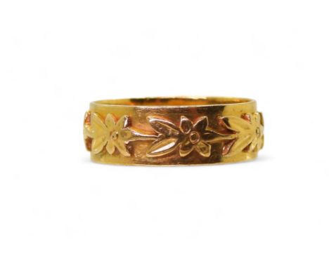 A 22ct gold wedding ring with a flower pattern, size O1/2, weight 6gms Condition Report:Available upon request