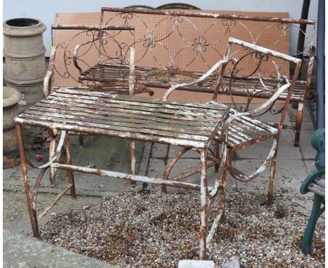 A late 19th century wrought iron garden suite, in the manner of Coalbrookdale, comprising of a bench, a pair of armchairs and