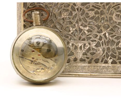 An Indian white metal and glass decanter, with pierced foliate decoration and a bulls eye clock, 23cm high Provenance: From t