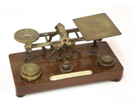 A set of Samson Mordan brass postal scales, with seven associated weights and an applied plaque, 'any letter exceeding 12oz w