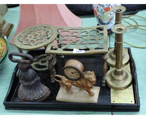 A spelter lion clock, Victorian brass candlesticks, trivets etc
