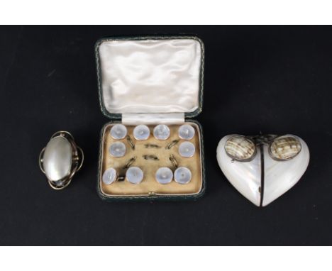 A mother of pearl crucifix and button set yellow metal mounted brooch, a large shell pendant, heart shaped mounted in white m