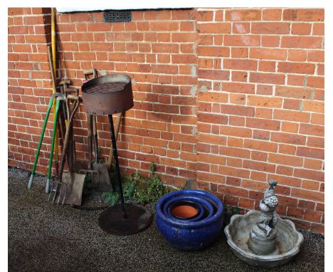 Various garden tools, a fire pit, blue ceramic garden pots and a cherub bird bath
