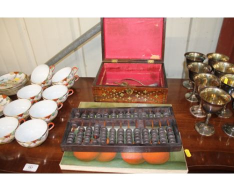 A wooden abacus; two prints on canvas of fruit; and a 19th Century wooden and brass inlaid box; together with a plated ladle;