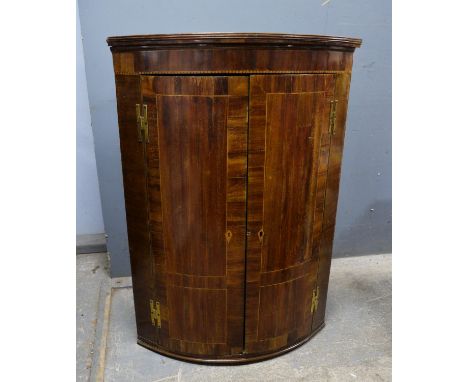 A George Third mahogany and herringbone inlaid corner cupboard, two cupboard doors enclosing painted shelves. 100c m high x 7