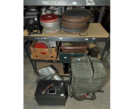 Two Vintage stage lights, a vintage projector Cine Camera and a quantity of Film in tin protectors.
